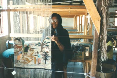 Odi Village, June 1995: This weaver is telling the story of the gathering and drying of thatch. Thatch harvested from palms and other native plants provides the roofs for many rondavals (round dwellings within a living compound). The thatching process is a very important task of village life and involves both the men and the women. This weaving also shows firewood that has been gathered from the communal lands outside of the village. It will be used by this family for cooking fires and for warming fires. The use of fire for social gatherings is an important part of Botswana culture.  Photo by Returned Peace Corps Volunteer Susan Ross.